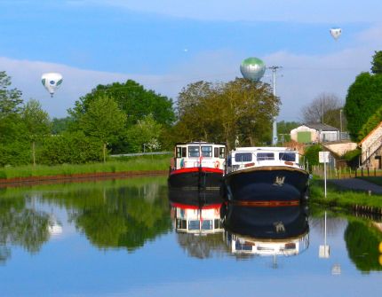A flock of Montgolfiers - hot air balloons - flew overhead and landed in a field in front of the boat.
